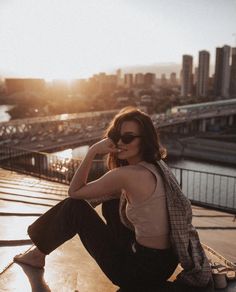 a woman sitting on top of a roof next to a river