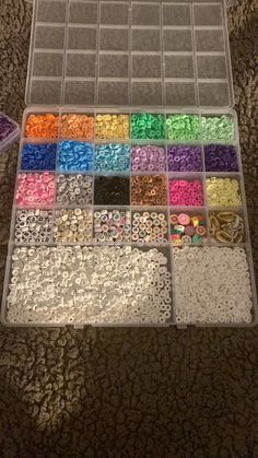 a plastic box filled with lots of different colored beads and other items on the floor