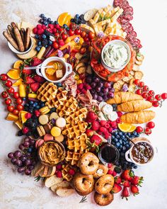 an assortment of food is arranged in the shape of a heart on a white surface