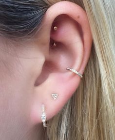 a close up of a person's ear with two different piercings on it