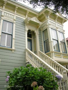 an old house with white trim and blue shutters