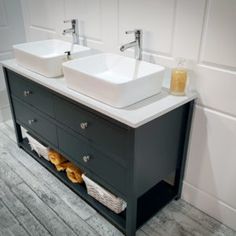 two white sinks sitting on top of a wooden cabinet