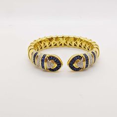 For Sale on 1stDibs - No details were spared in this beautiful 18 karat yellow gold cuff bracelet. Long tapered blue sapphires and pave round brilliant diamonds are set forming Yellow Gold Cuff Bracelet, Gold Cuff Bracelet, Gold Bracelet Cuff, Gold Cuffs, Brilliant Diamond, Round Brilliant, Karate, Cuff Bracelet, Blue Sapphire