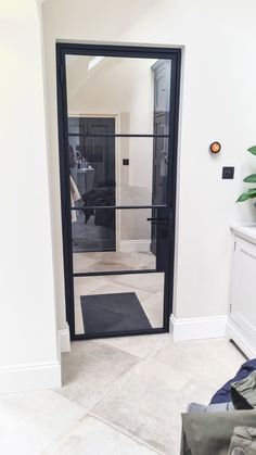 an open door leading into a bedroom with a black mat on the floor and a plant in the corner