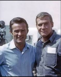 two men standing next to each other in front of a cameraman's equipment