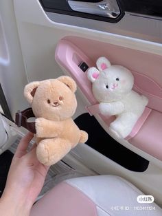 a person holding a teddy bear in their car seat with another stuffed animal behind them