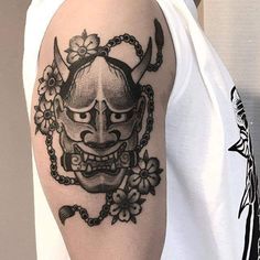 a man with a tattoo on his arm wearing a mask and chain around his neck