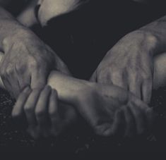 two hands holding each other in the middle of their arms, with one hand resting on another's chest