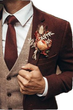 a man wearing a suit and tie with a boutonniere on his lapel