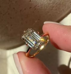 someone is holding an engagement ring that has a large diamond in it's center