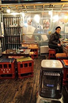 a man sitting on top of a wooden floor next to crates