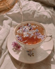 tea being poured into a cup filled with flowers