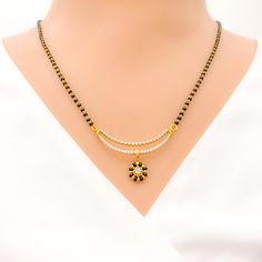 Elevate your style with our Floral Black Bead Drop Mangal Sutra. Crafted in 18k yellow gold, the diamond pendant boasts 0.56 ct diamonds in round brilliant cut, while the 22k black bead chain adds a bold contrast. Weighing 3.6 grams, this necklace is 19.5 inches long with an adjustable hook lock. PRODUCT DETAILS Diamond Pendant Gold Purity(karat): 18k Item Weight(grams): 3.6 Item Finish: Yellow Gold Stone: Diamond Diamond Weight(carats): 0.56 ct Diamond Color: F-G Diamond Quality: VS Diamond Sha Black 22k Gold Jewelry With Round Beads, Black Temple Jewelry With Gold Beads, Traditional Yellow Gold Jewelry With Black Beads, Black Diamond Jewelry With Diamond Eyes, Black 22k Gold Necklace For Weddings, Traditional Black Jewelry With Round Pendant, Traditional Black Diamond Necklace, Traditional Black Round Pendant Jewelry, Black 22k Gold Jewelry As A Gift