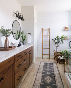 a bathroom with wooden cabinets and a rug on the floor next to it's sink