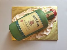 a bottle of jameson sitting on top of a piece of gold foil next to a bottle of wine