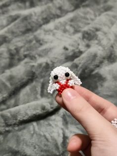 someone is holding a tiny beaded animal in their hand