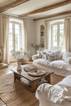 a living room filled with white furniture and lots of window sill covered in curtains