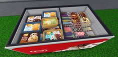 an open box filled with lots of different types of food on top of green grass