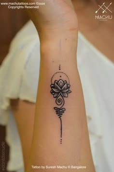 a woman's arm with a flower tattoo on it