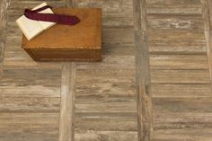 a wooden box with a tie on top of it next to a floor tile design