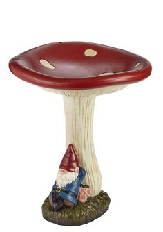 a gnome sitting under a mushroom shaped table