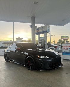 a black sports car parked at a gas station