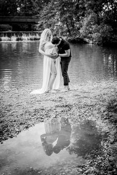 a man and woman standing next to each other near water