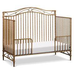 a crib that is made out of wood and has white sheets on the bottom