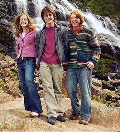 three people standing in front of a waterfall