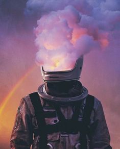 a man wearing a space suit and helmet with a rainbow in the sky behind him