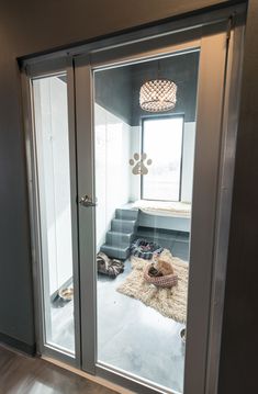 an open glass door leading to a bedroom with a dog bed on the floor in front of it