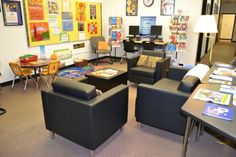 a room with chairs, tables and pictures on the wall