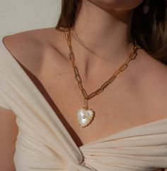 This super adjustable paperclip chain is elevated to new heights with our Malene heart charm in luminous mother of pearl. Carved stone, cubic zirconia, and high-shine gold. Everything you want and need in a statement necklace. 14k gold plated 6.5mm large Allegra elongated chain with carved mother of pearl and cubic zirconia heart pendant. Fully adjustable up to 16" in total length. Luxury Mother Of Pearl Necklace, Pearl Heart Necklace, Gold Everything, Want And Need, Pearl Heart, Carved Stone, Mini Rodini, Stone Carving, Black Mini