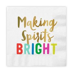 a white napkin with the words making spirits bright printed in gold and rainbow on it