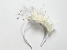 Ivory bridal feather crown This lovely Ivory color feather fascinator is made from high-quality feathers.  The ivory feather fascinator is attached to a white silk-covered metal headband. Feather Fascinator is very stylish and at the same time simple. You can wear it on any occasion like Christening, Wedding, Royal Ascot or Kentucky Derby races. This piece is timeless. I hope you enjoy it! Kristine xx White Feathered Fascinator For Wedding, White Ostrich Feather Headpiece With Feather Trim, White Ostrich Feather Wedding Headpiece, Cream Feathered Wedding Fascinator, Off White Wedding, Wedding Royal, Feather Crown, Large Brim Hat, Halo Crown