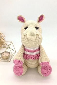 a crocheted stuffed animal sitting next to a candle holder