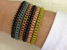 a close up of a person's arm wearing bracelets with beads on it