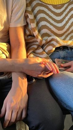 two people sitting next to each other with their hands on top of one another's legs