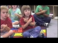 several children sitting on the floor with their hands together