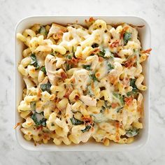 a casserole dish with chicken and spinach in it on a marble surface