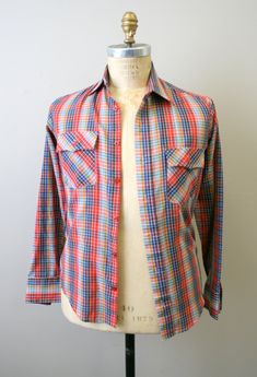 "Description: 1970s multi-colored checked men's shirt. Button front. With two chest pockets with button flaps. Cotton/polyester blend. Condition: In good condition, with no holes or stains. It does have a few pin sized spots. Designer: n/a Stated Size: n/a Measurements: Armpit to armpit: 19.5\" Shoulder to shoulder: 16.25\" Overall length: 29\" Sleeve length: 24.5\" Waist: 34\" ---> If you need an order shipped by a particular date or shipped via a quicker method, please ask PRIOR to purchase Retro Collared Flannel Shirt With Button Closure, Retro Collared Flannel Shirt With Pockets, Retro Button-up Flannel Shirt, Retro Collared Flannel Shirt, Retro Plaid Flannel Shirt With Buttons, Mens Oxfords, Shirt Button, Chest Pocket, Multi Colored