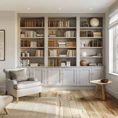 a living room filled with furniture and bookshelves next to a large window on top of a hard wood floor