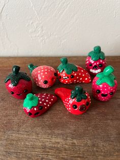 several small plastic strawberries sitting on top of a wooden table next to each other