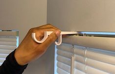 a person is pulling the handle on a window blind