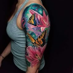 a woman's arm with tattoos on it and butterflies in the sky above her