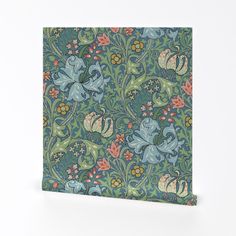 a blue and green wallpaper with floral designs on the bottom, along with leaves and flowers