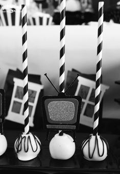 black and white photo of candy apples with candles in front of tv set on table