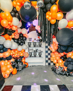 an entrance decorated with black, white and orange balloons