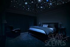 a bedroom with stars on the ceiling and a bed in the middle is lit up