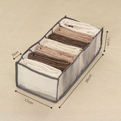 an organized drawer is shown with the measurements for folded clothes in front of it and on the floor